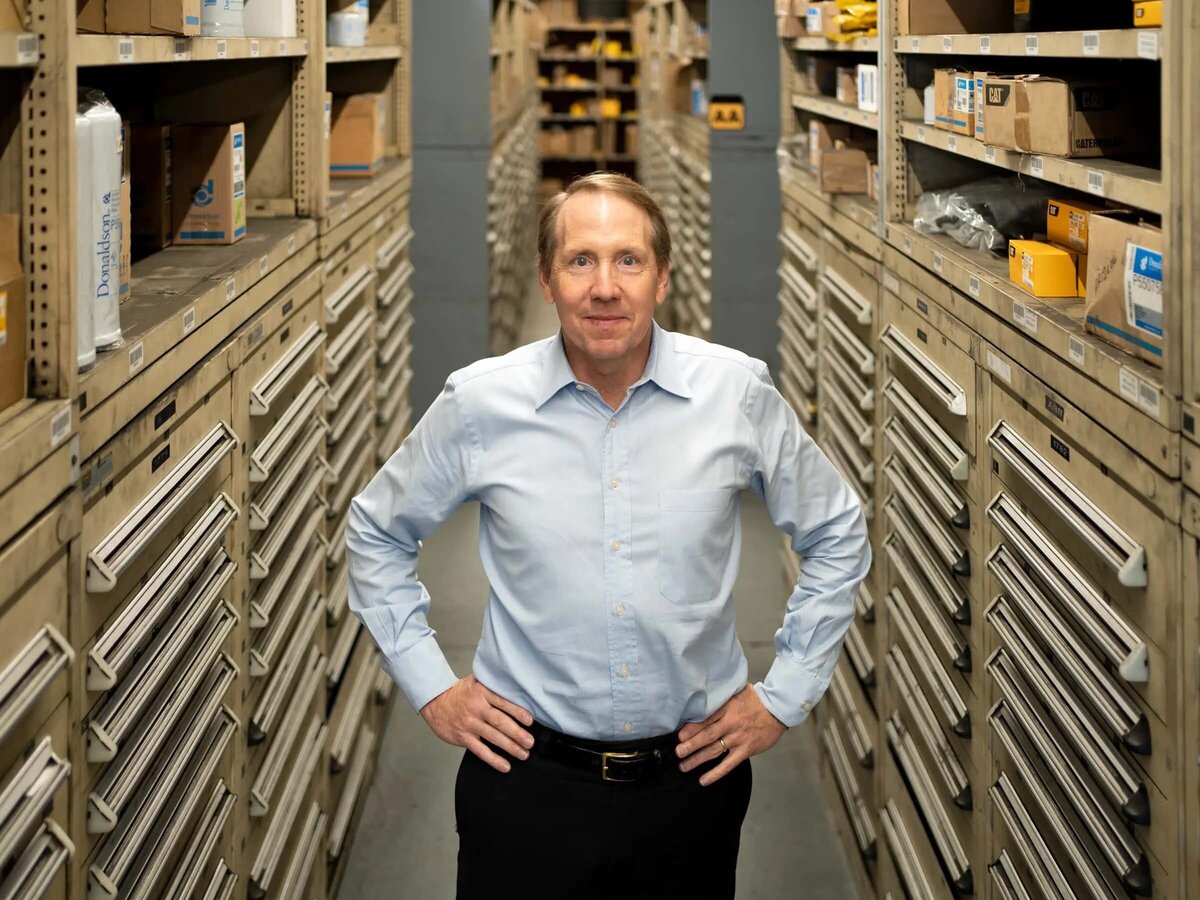 A man standing with his hands on his hip in between rows of drawers