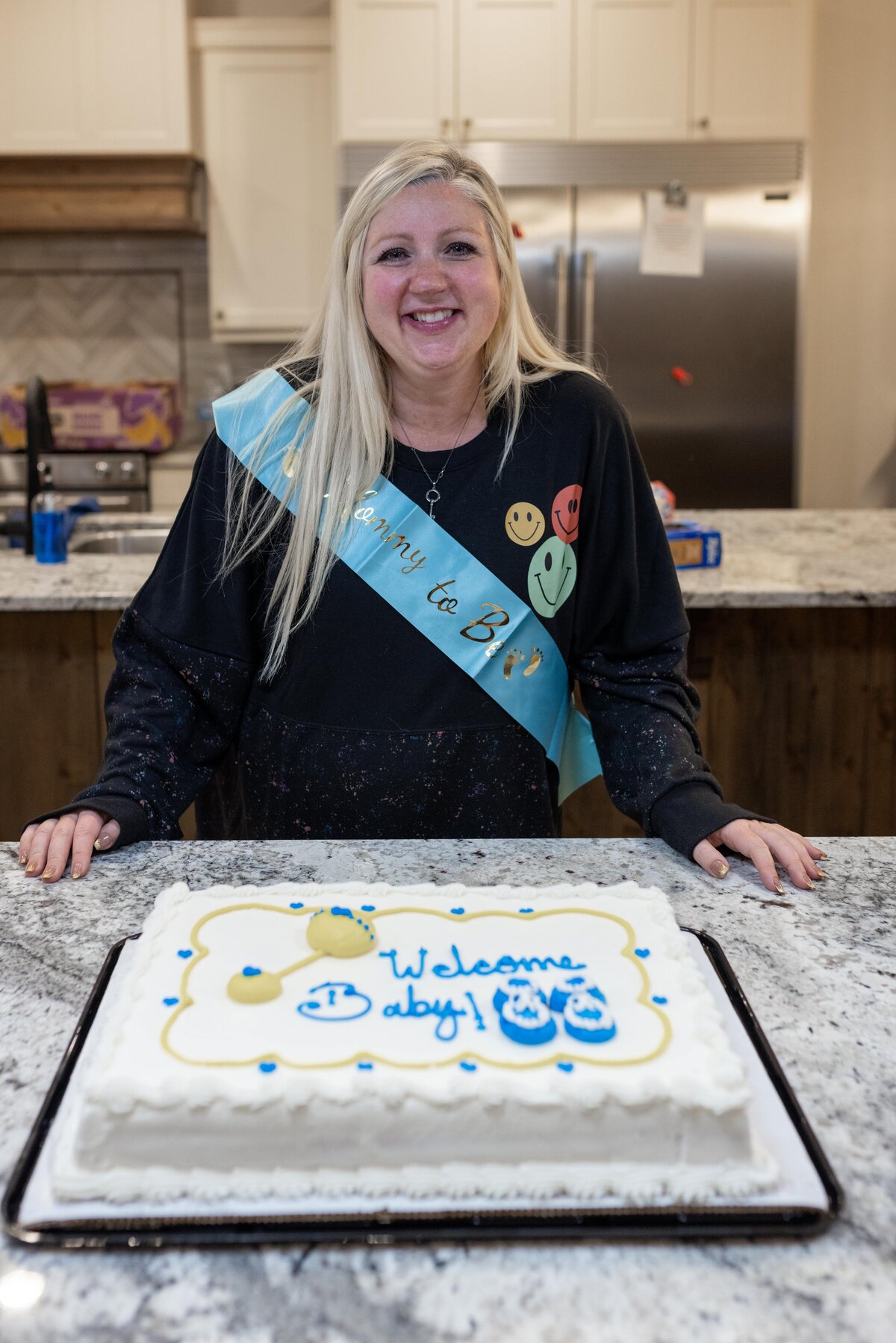 blonde woman with a cake celebrating her pregnancy