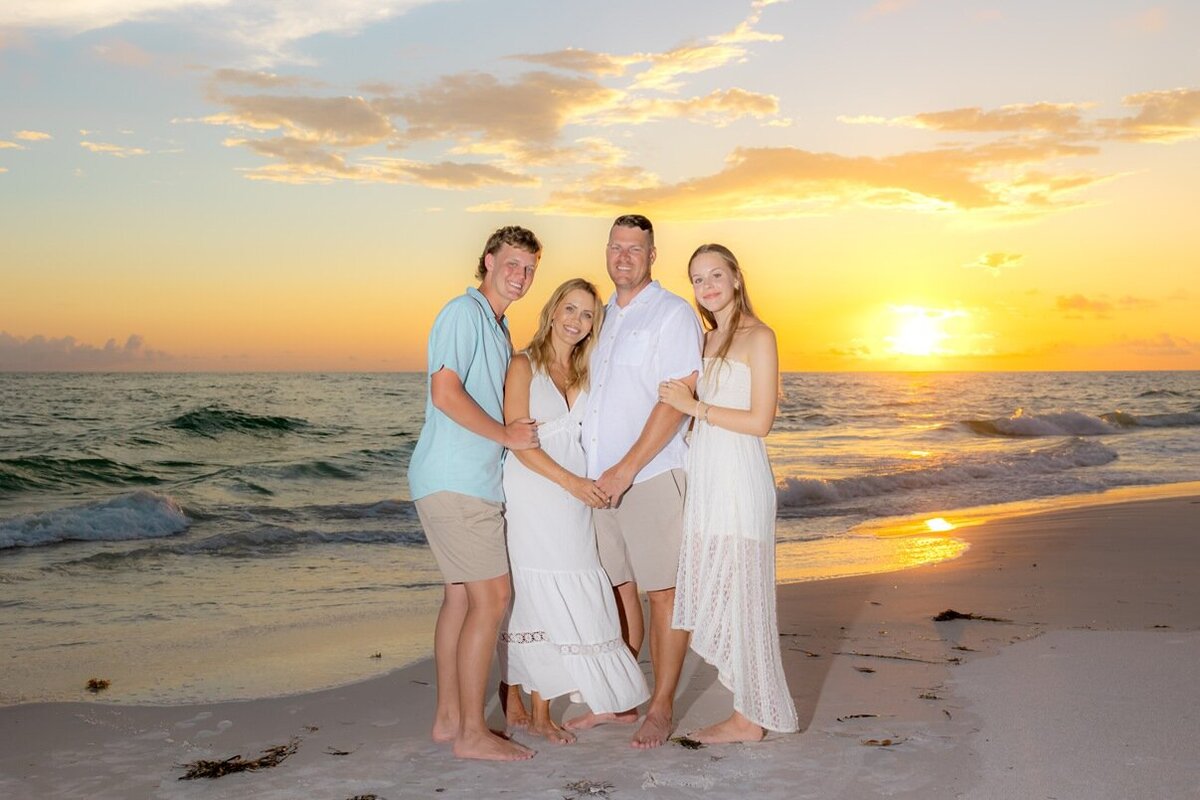 Parents with teen kids pose for a shot in the evening