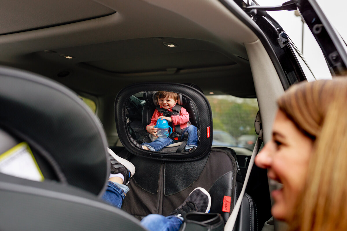 mom-putting-toddler-car