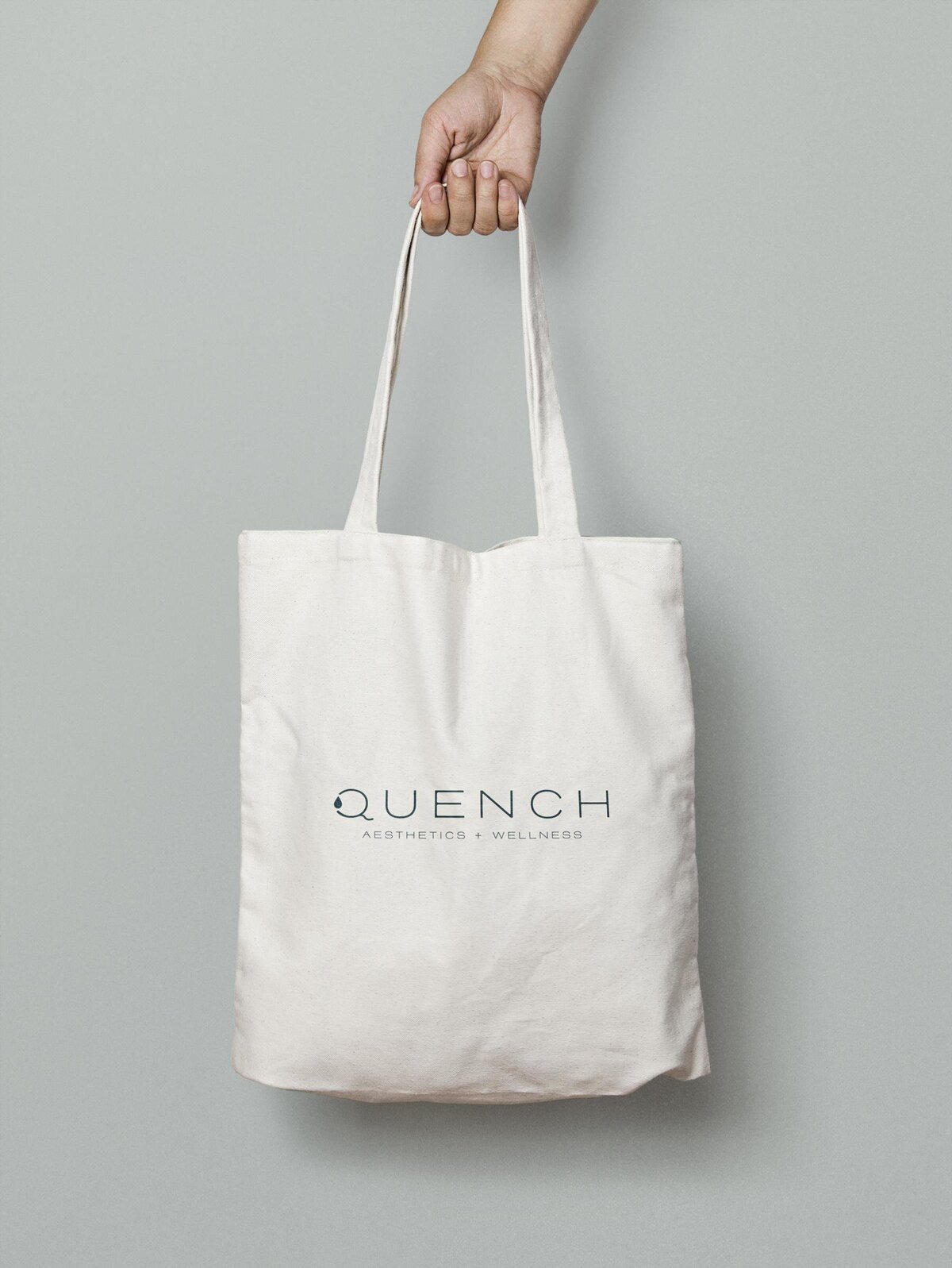 hand holding bag with quench logo