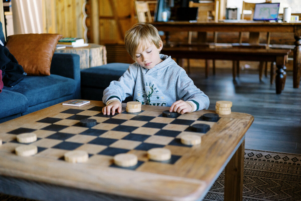 boy playing chess with his dad