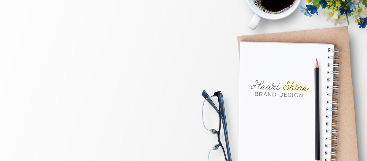 Brand strategist desk with journal, coffee, and glasses