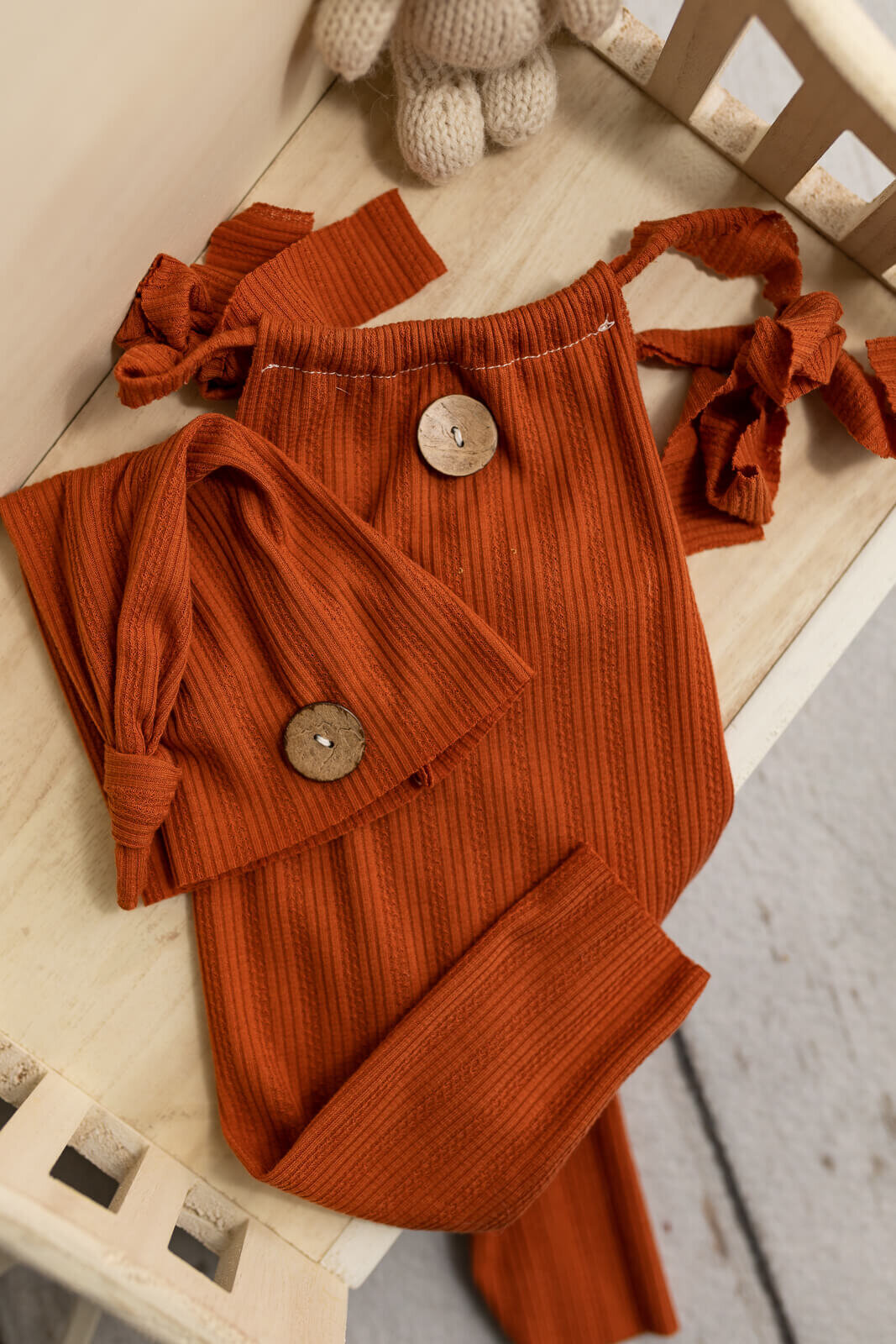 Burnt orange romper and sleepy cap set used for baby girl photo session.