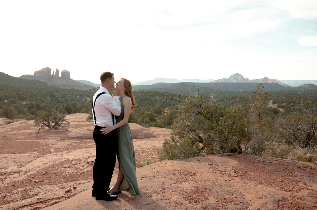Couple standing against red rock backdrop during Sedona engagement session