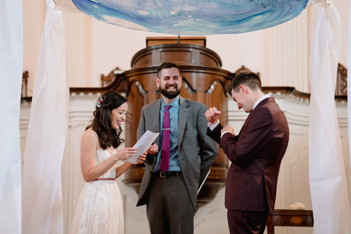 A couple during their wedding ceremony while one is reading their vows.
