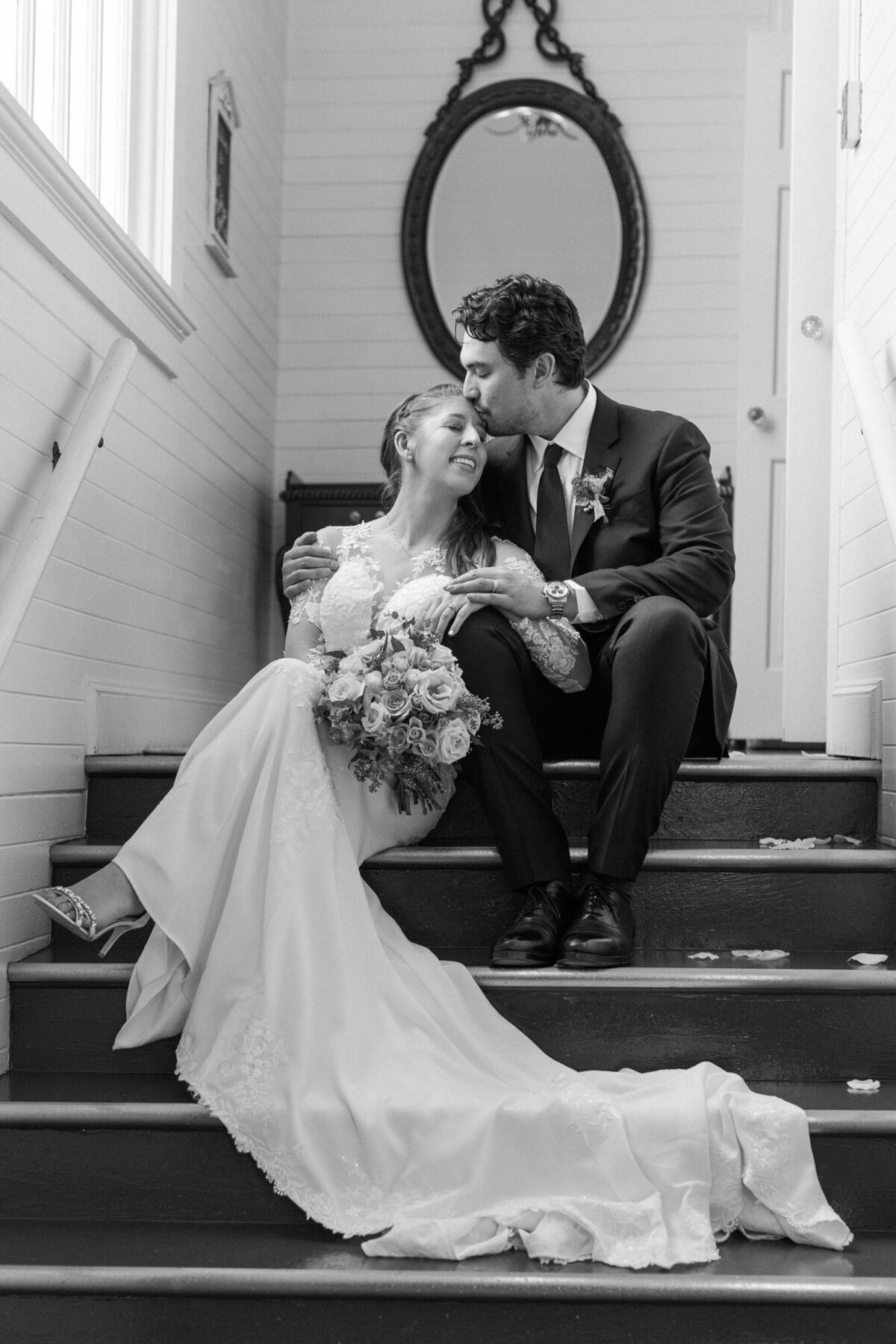 Black-and-white-photo-of-bride-and-groom-sitting-on-steps-at-historic-Belle-chapel-in-Snohomish-photo-by-Joanna-Monger-Photography