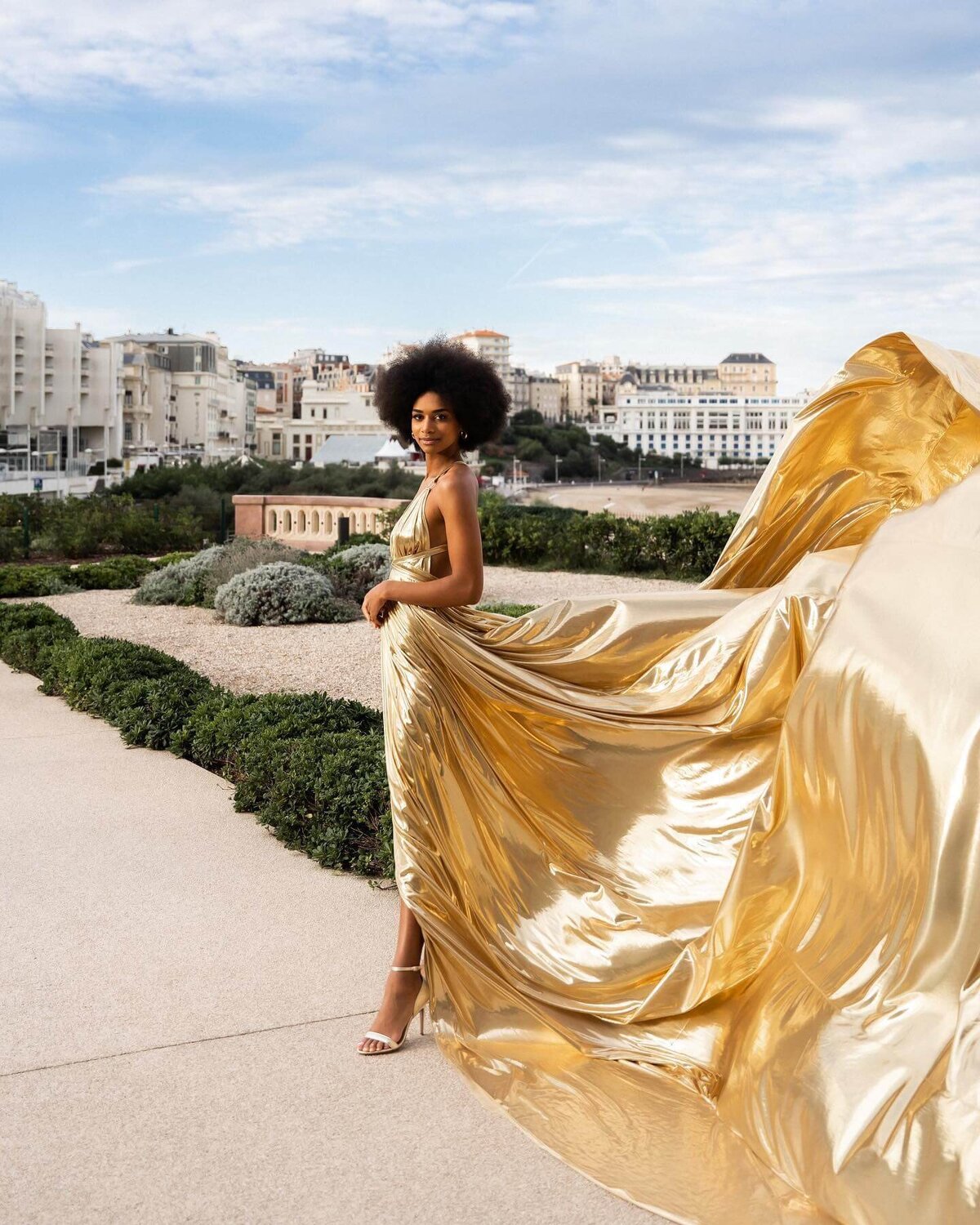 women having a portrait photoshoot in paris wearing a gold flying dress