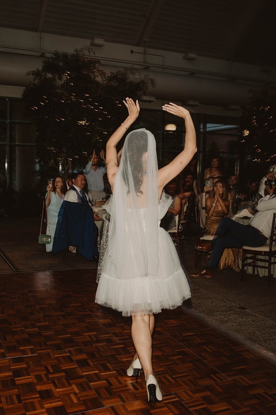 A person in a wedding dress walking onto a dance floor 