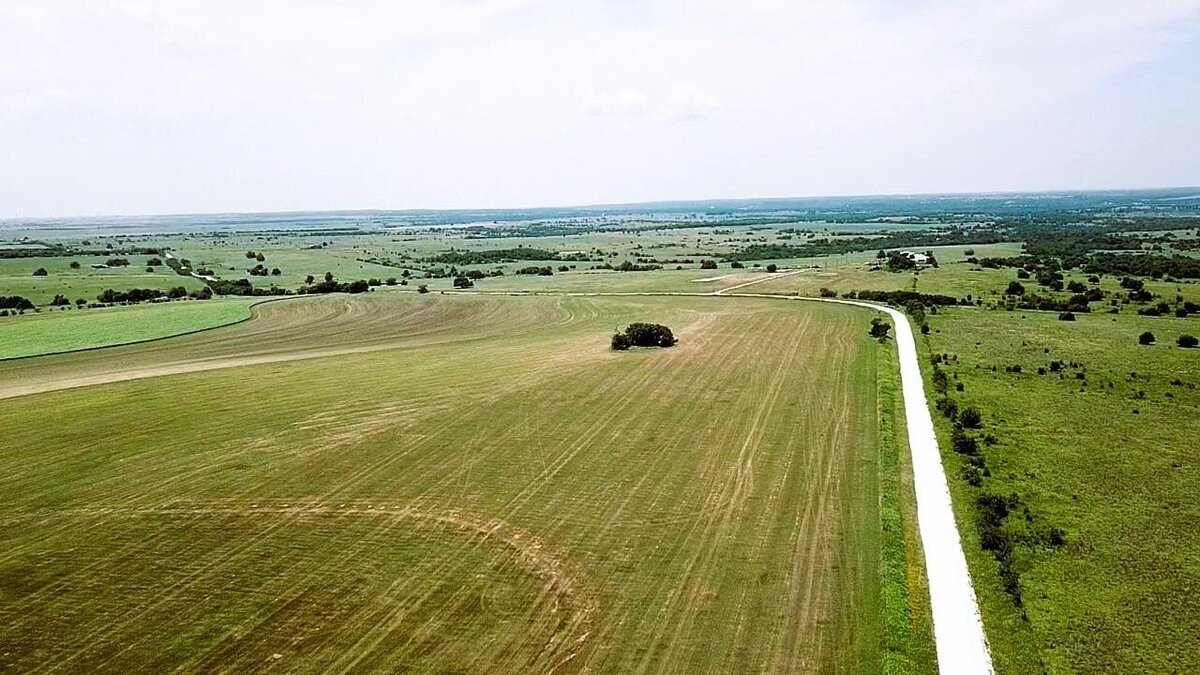 Aerial view of 11-acre property in Lindsay, Texas with open fields and clear skies