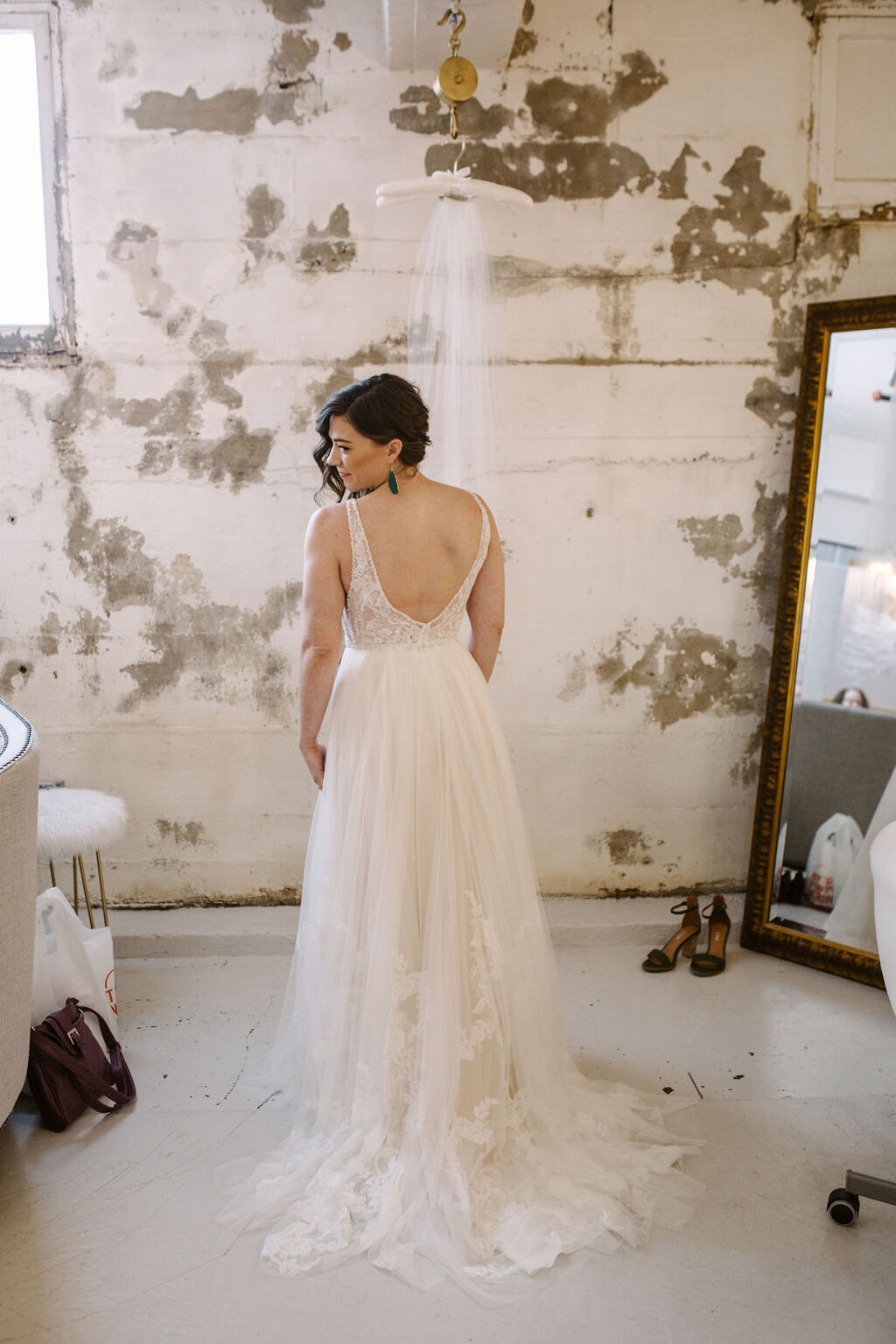 Bride standing in front of mirror iin bridal suite at the St Vrain