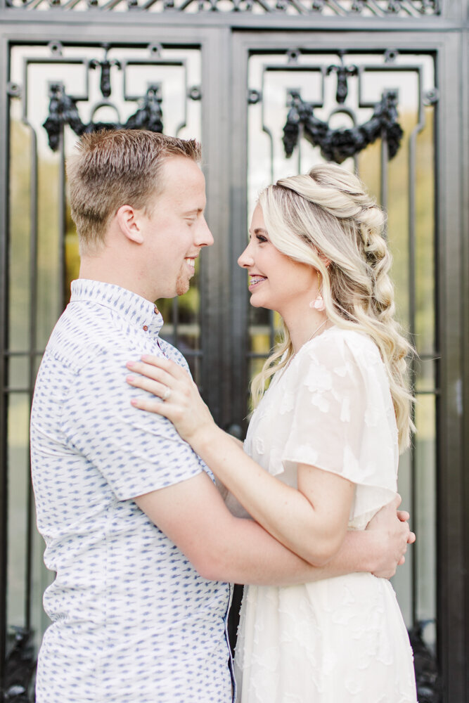 man and woman smiling at each other while standing in front of a door