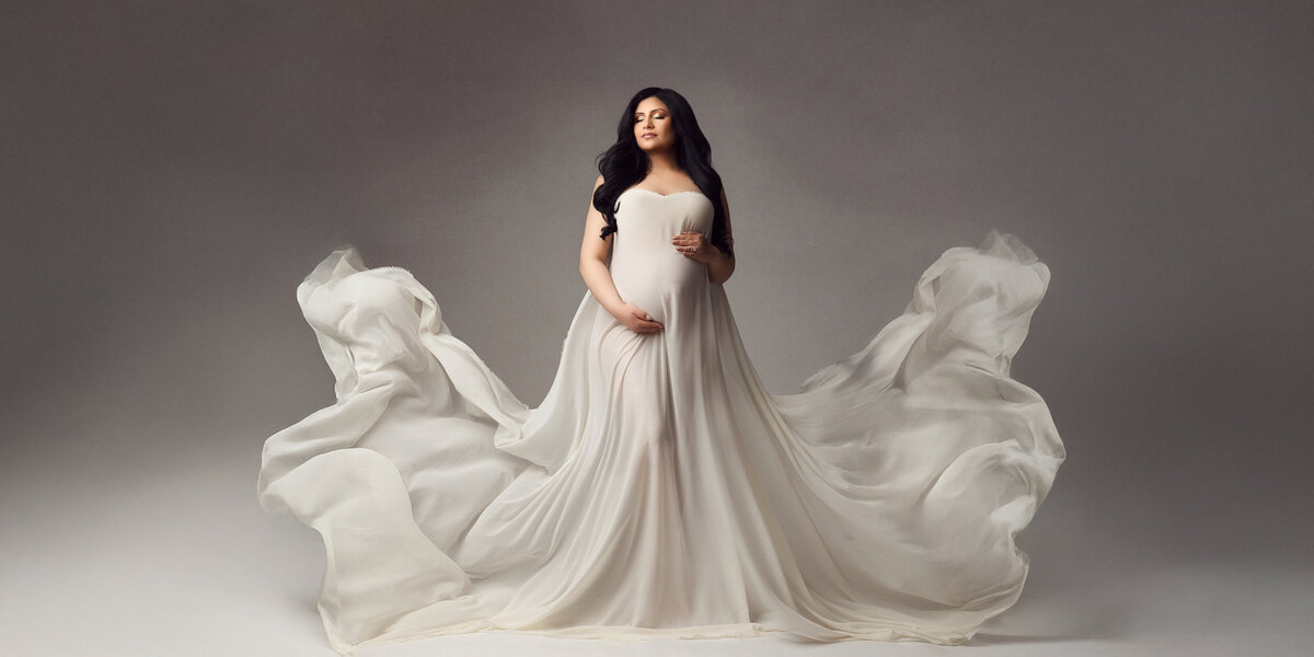 brunette pregnant mom wearing a royal blue silk gown