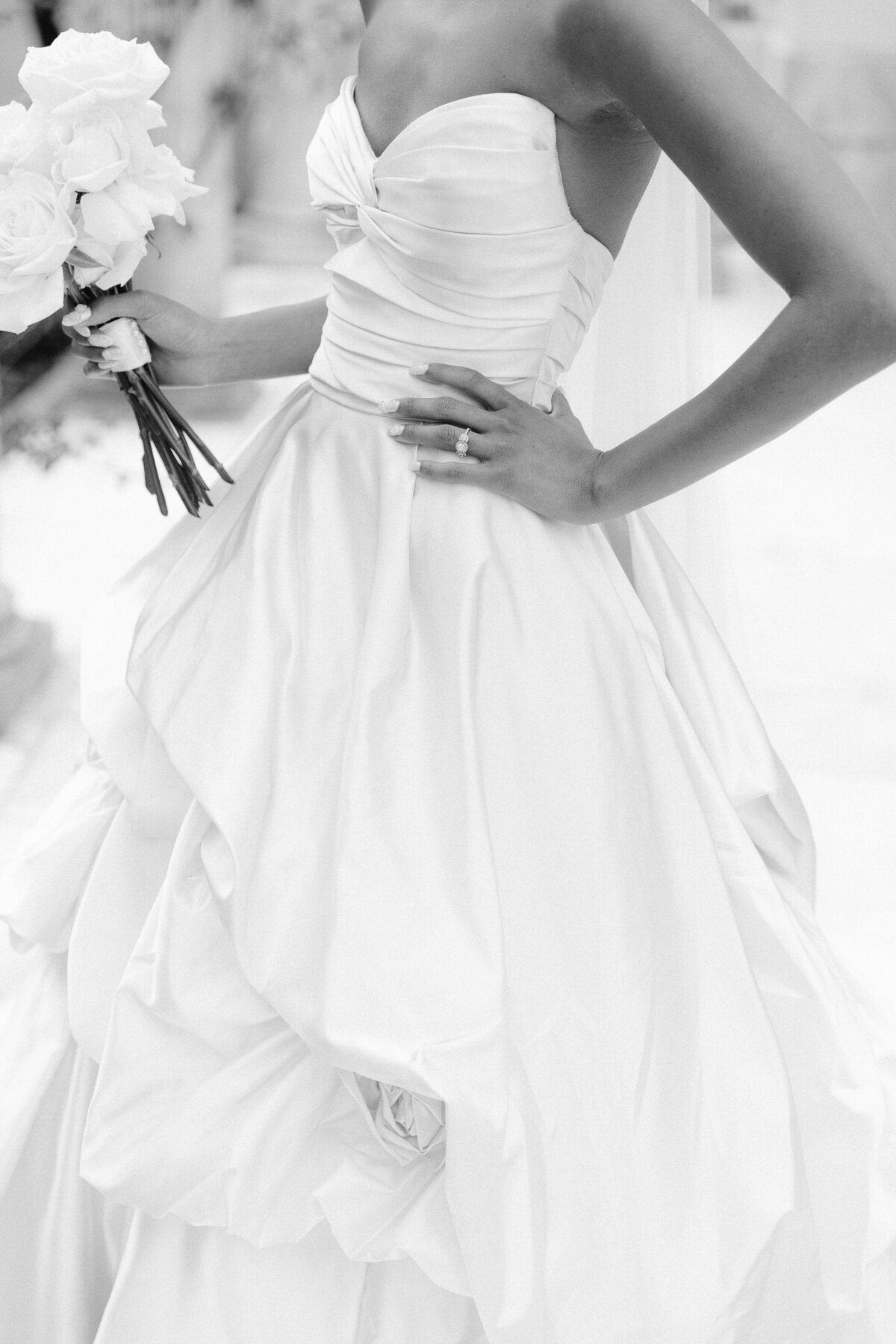 A bride wearing a monique lhuillier dress with her hand on hip