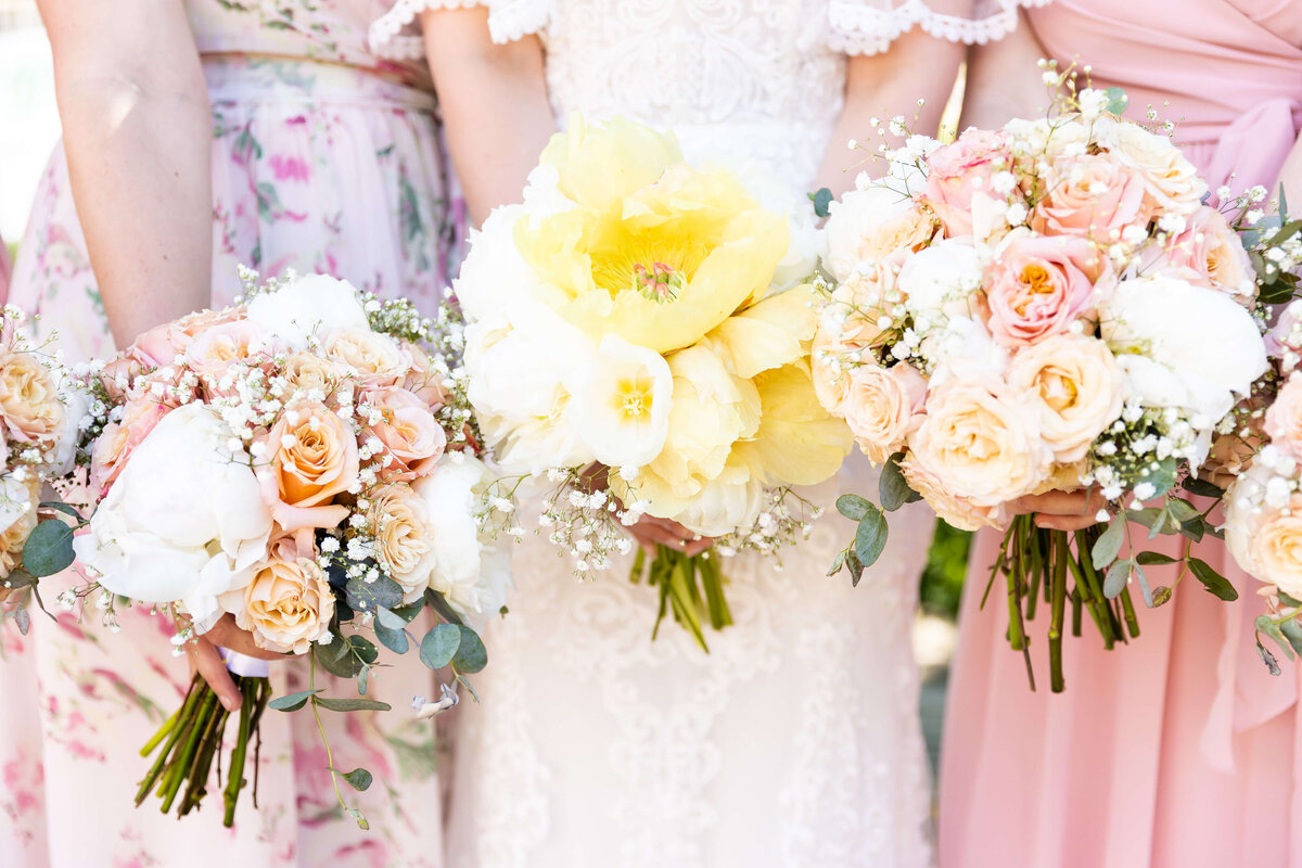 Bridesmaids holding boquets of yellow blush and ivory florals designed bt The Flower Smithy