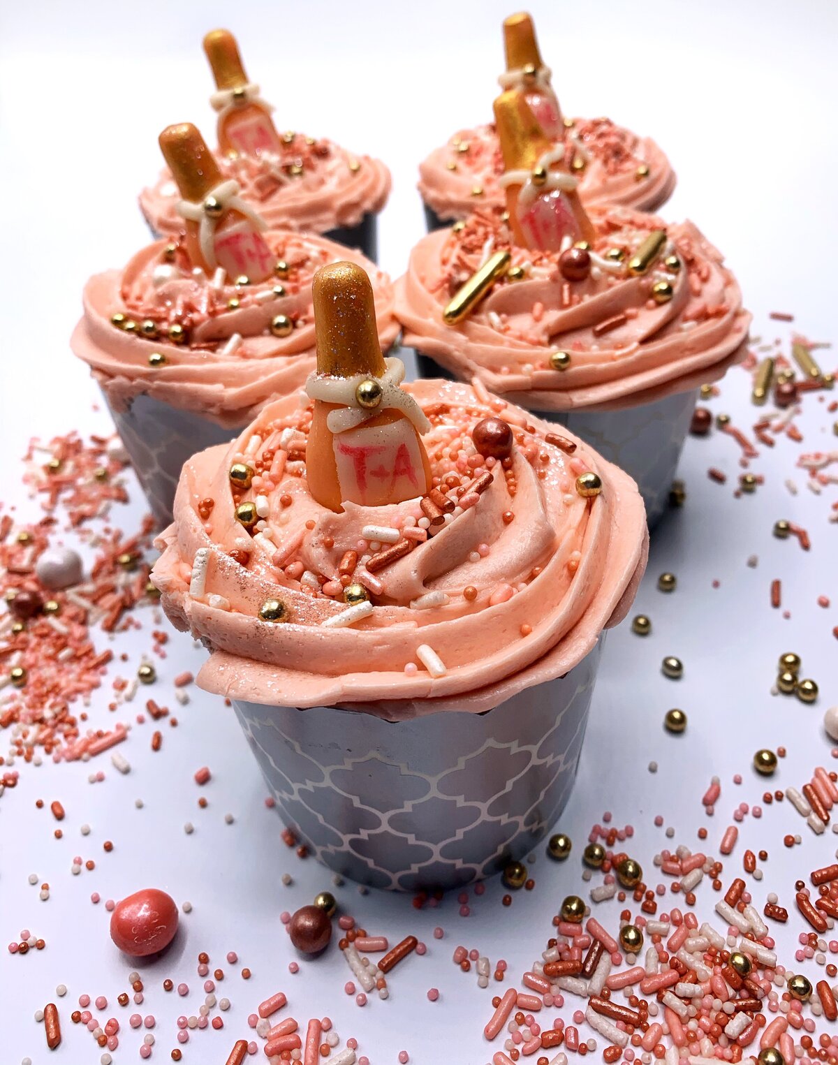Pink champagne cupcakes with modeled pink champagne bottle decorations