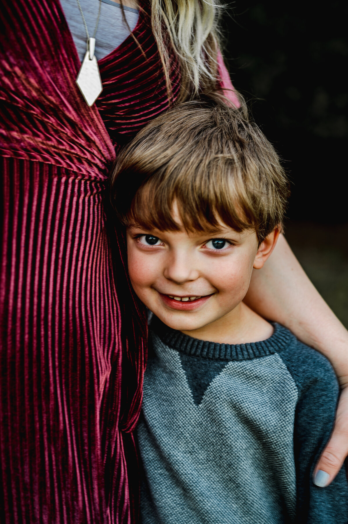 Young boy smiling at the camera during family photo session — joyful Fort Worth family photography by Poppy + Blue Photography
