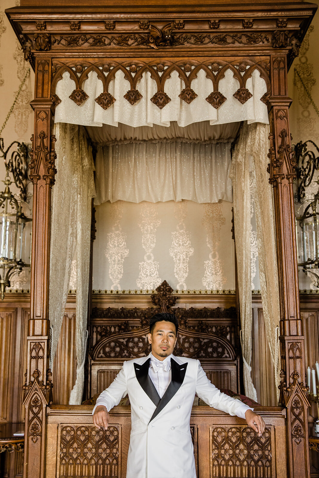 Groom posing in one of the elegant rooms at Château Challain, captured in stylish, fine-art wedding photography.