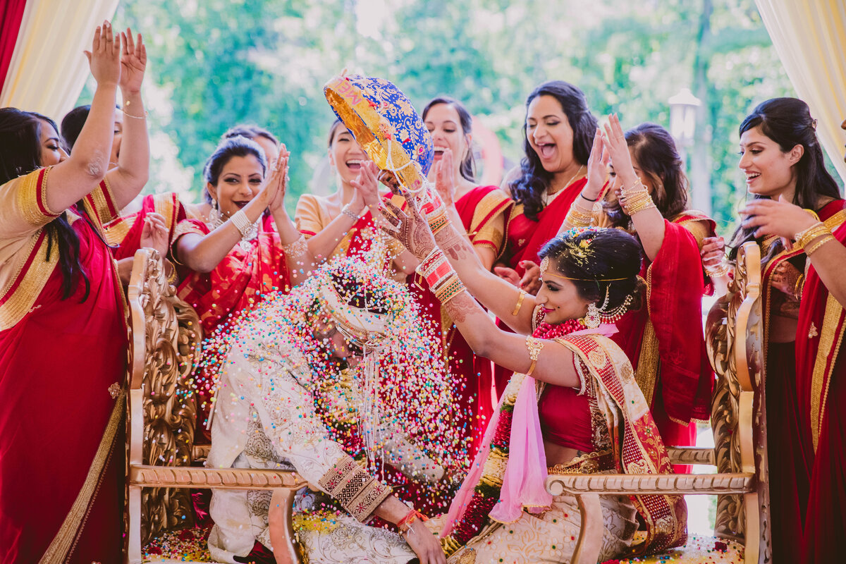 South Indian Telegu bride pouring colorful rice over the groom during their hindu ceremony at Brigalias, New Jersey