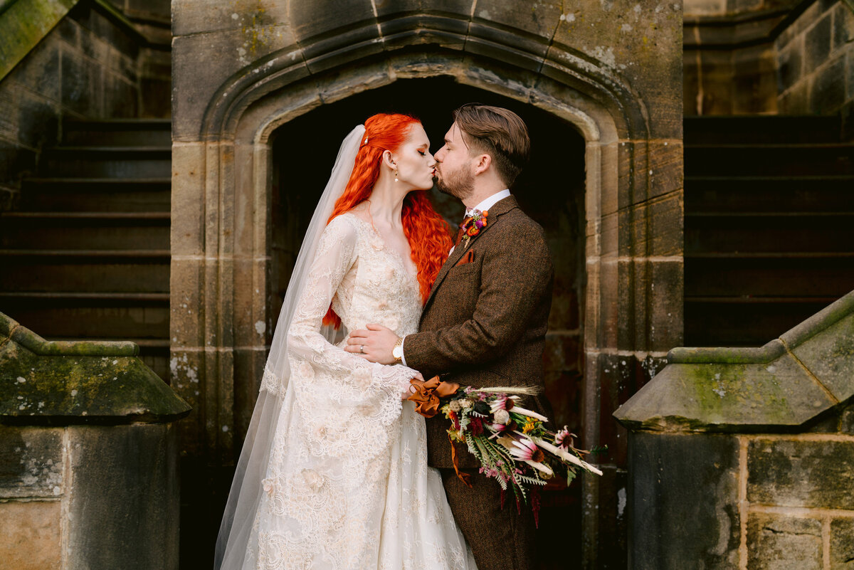 bride and groom kissing on the stairs at allerton castle