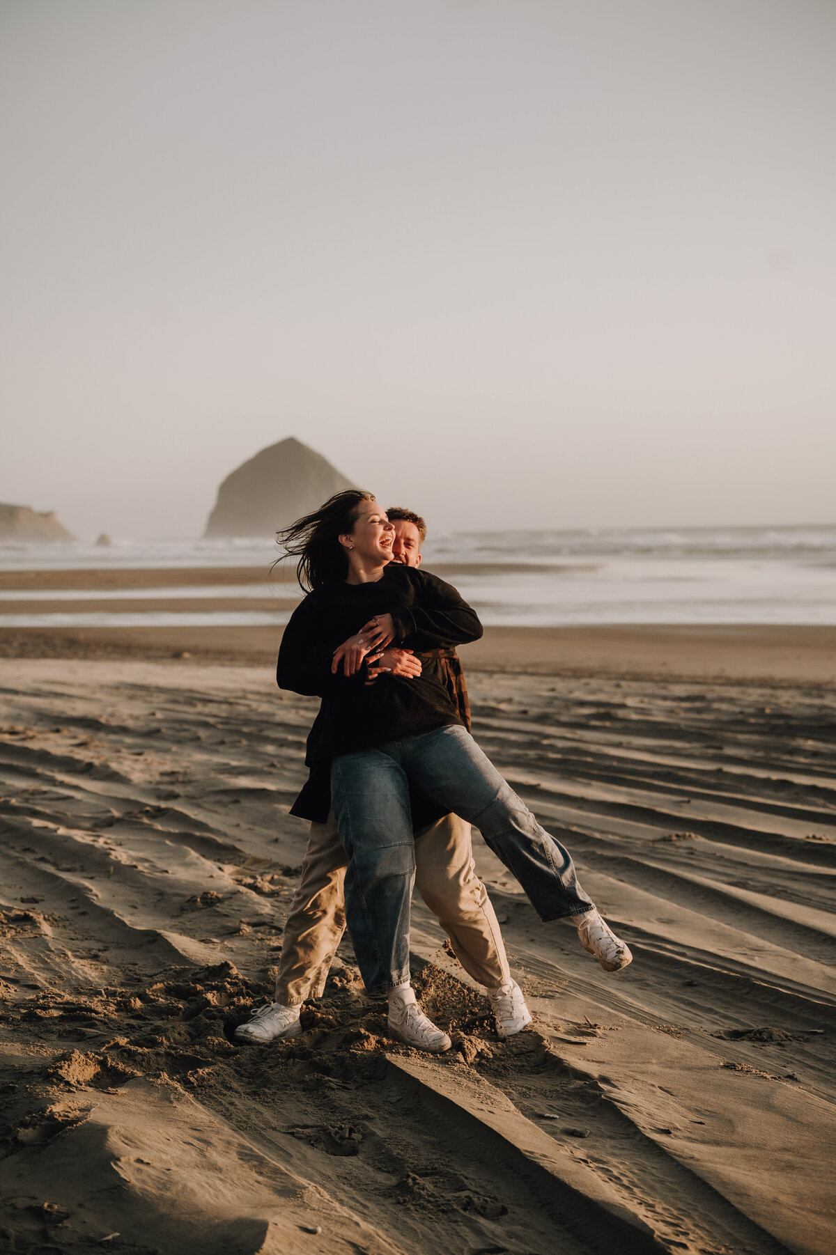 Candid photo of engaged couple on Canon Beach in Oregon