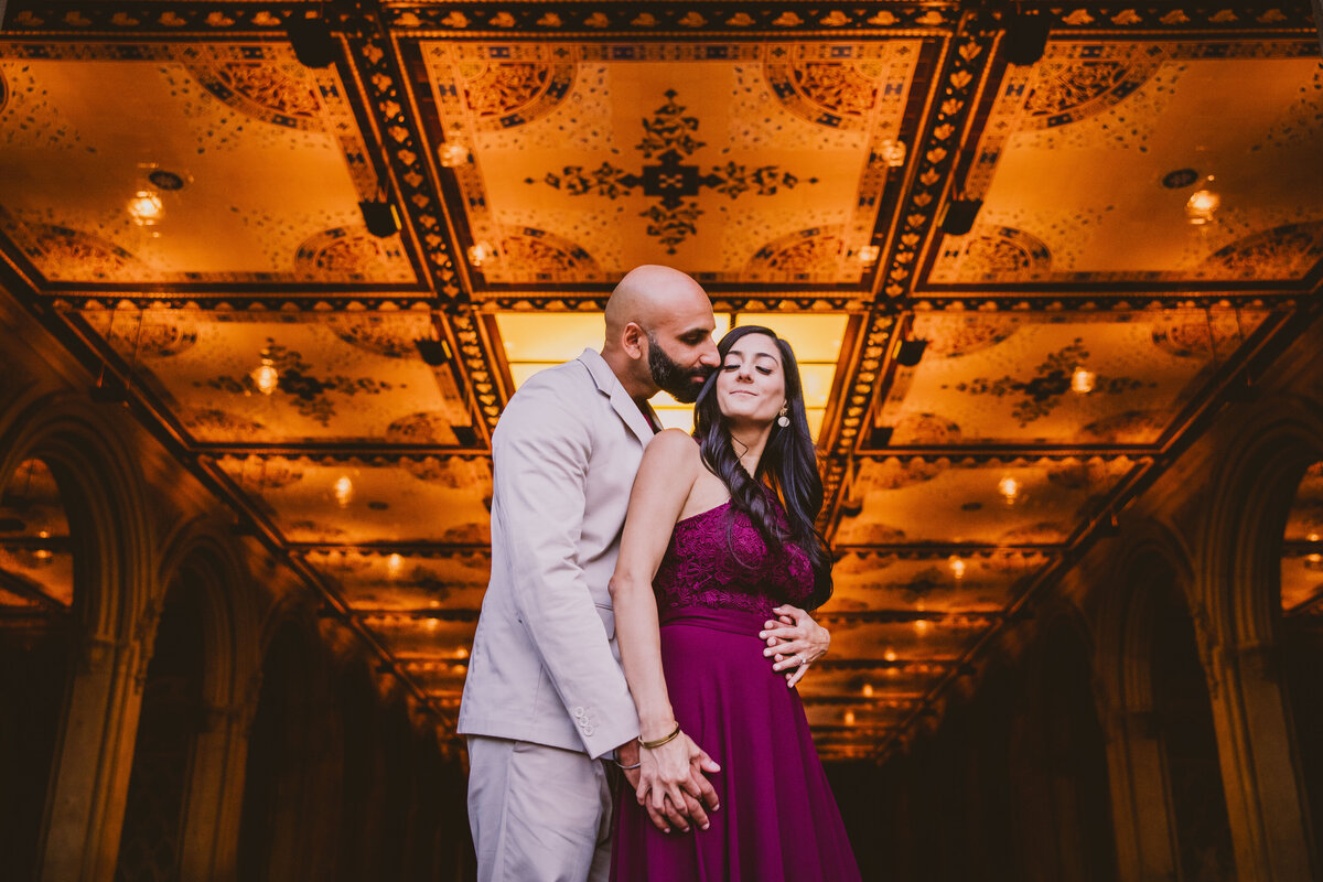 A couple sharing a moment at bethesda terrace arcade at central park with the ceiling tiles in view