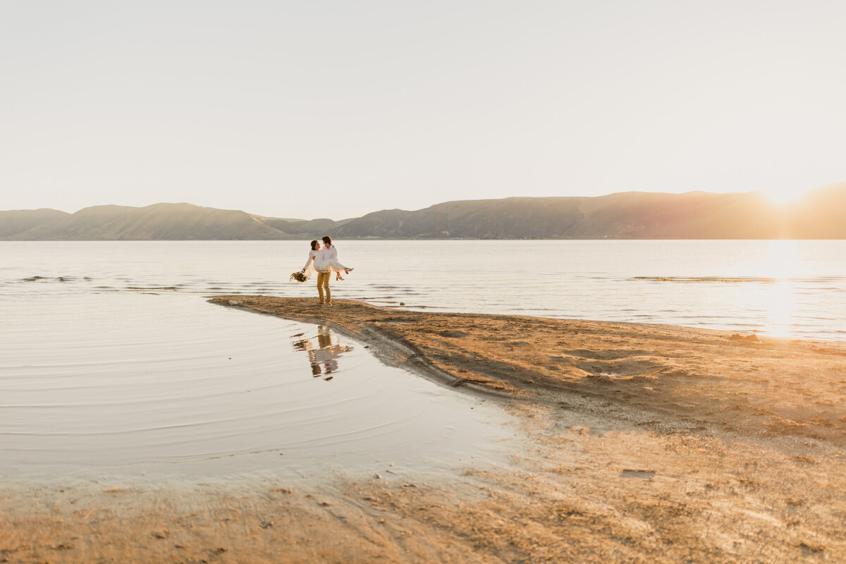 Logan Utah wedding Photographer takes this photo at sunrise of a couple in wedding clothes.