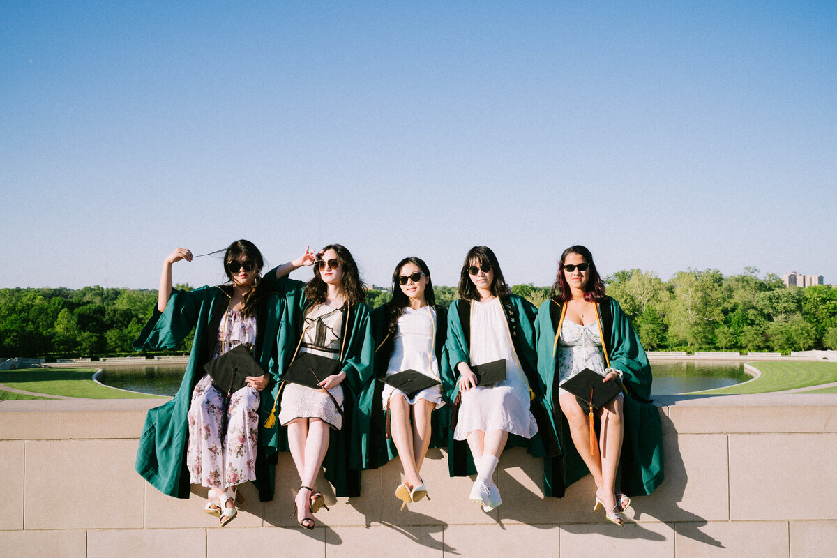 five friends sitting at the top of art hill in washu regalia
