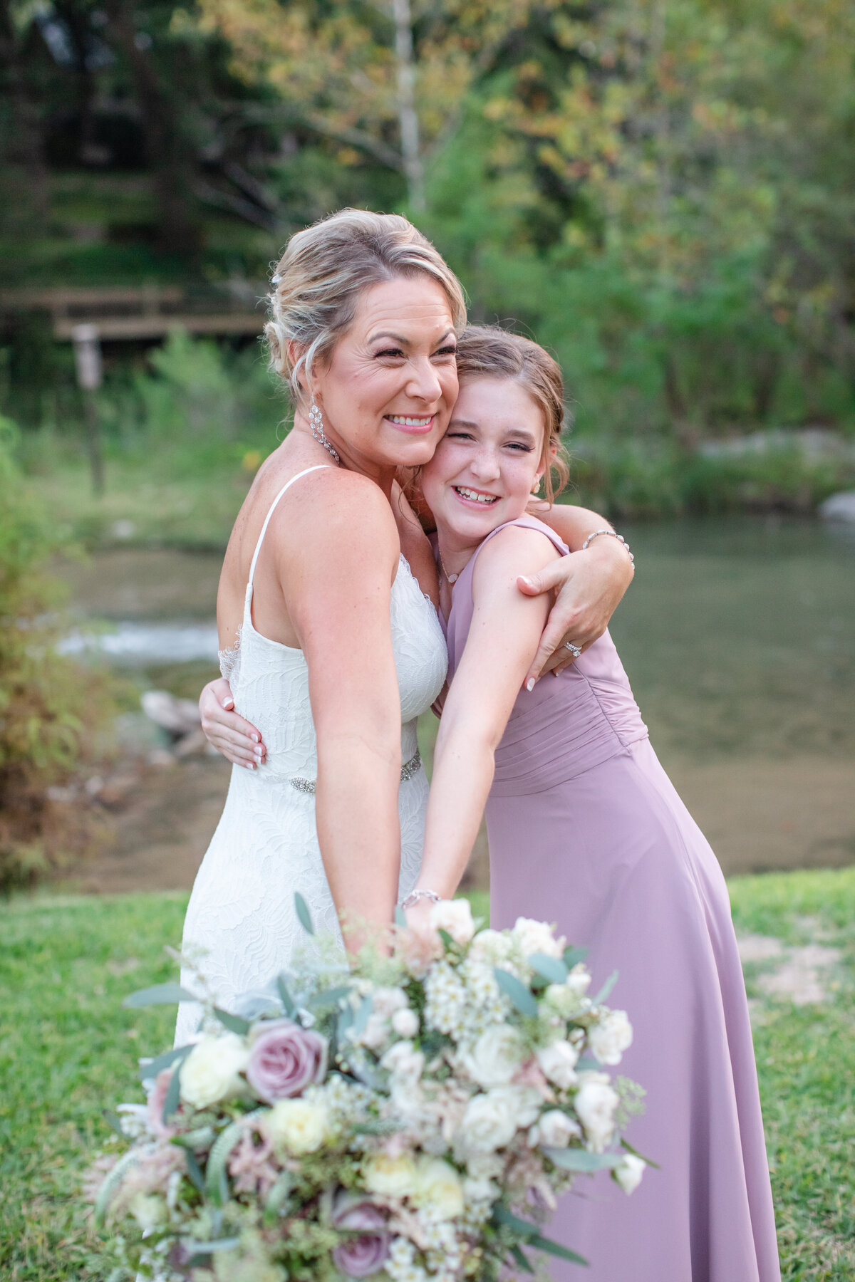 bride and daughter hug holding  mauve bouquet at wedding near Austin Texas