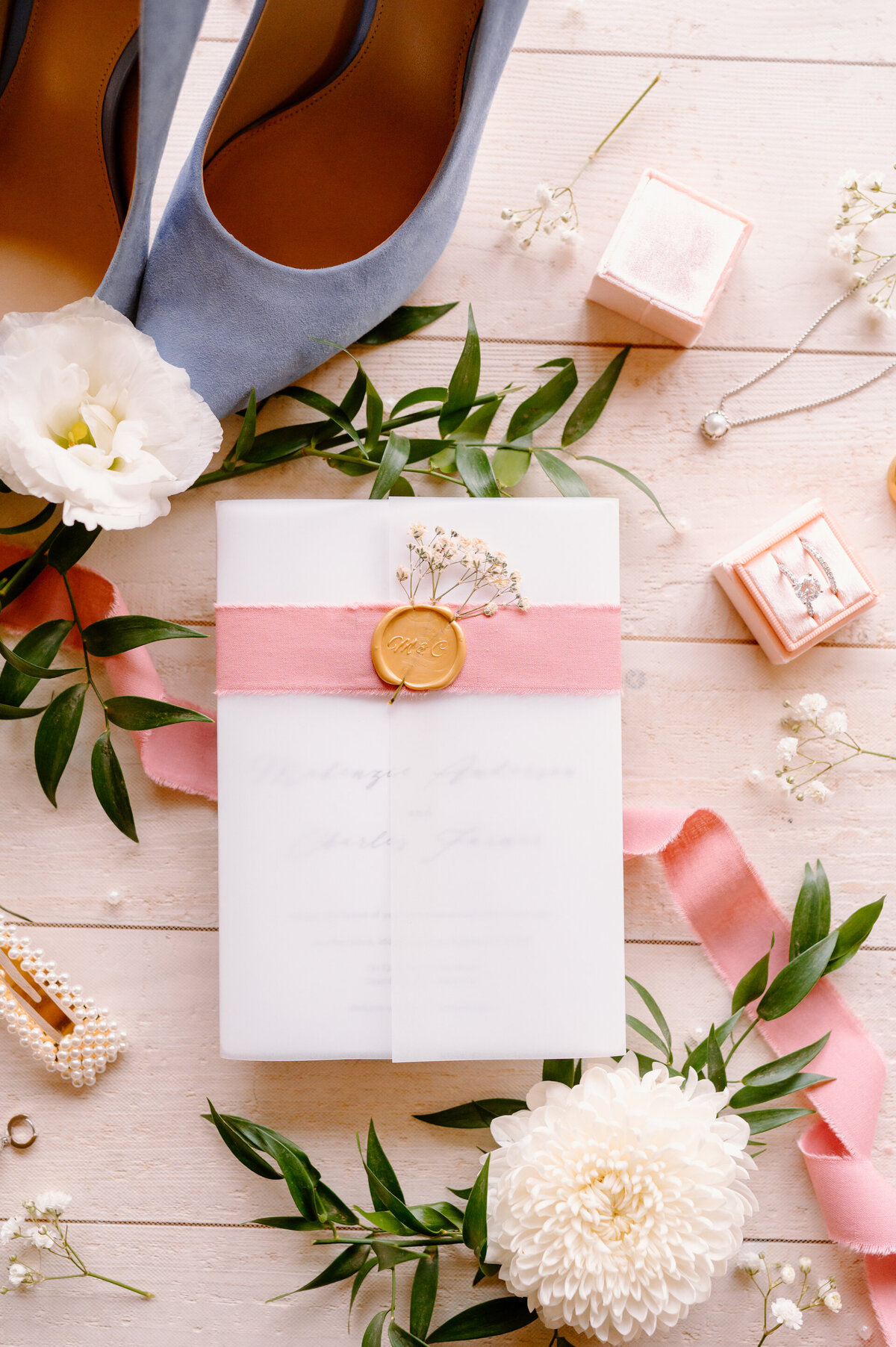 flat lay of pink, white, and blue wedding details