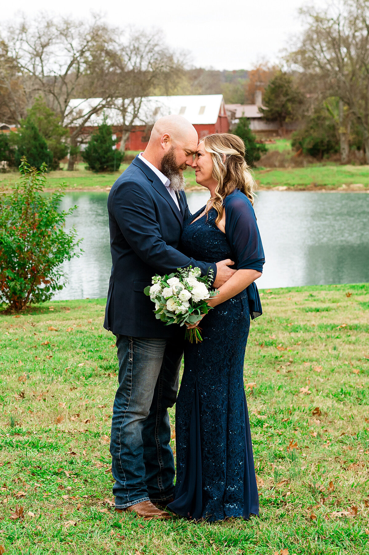 Romantic newlywed photo beside a pond and red barn