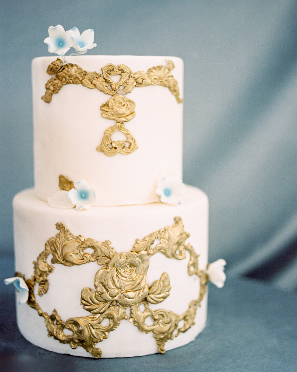 Cake with golden details on a blue velvet background