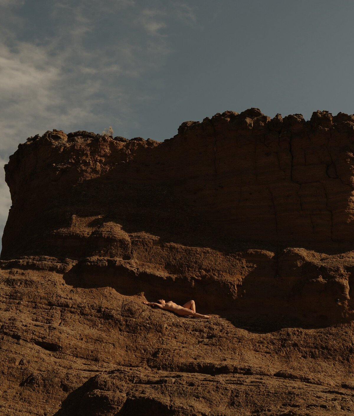 empowered woman laying on the sun lit rocks in Moab, Utah
