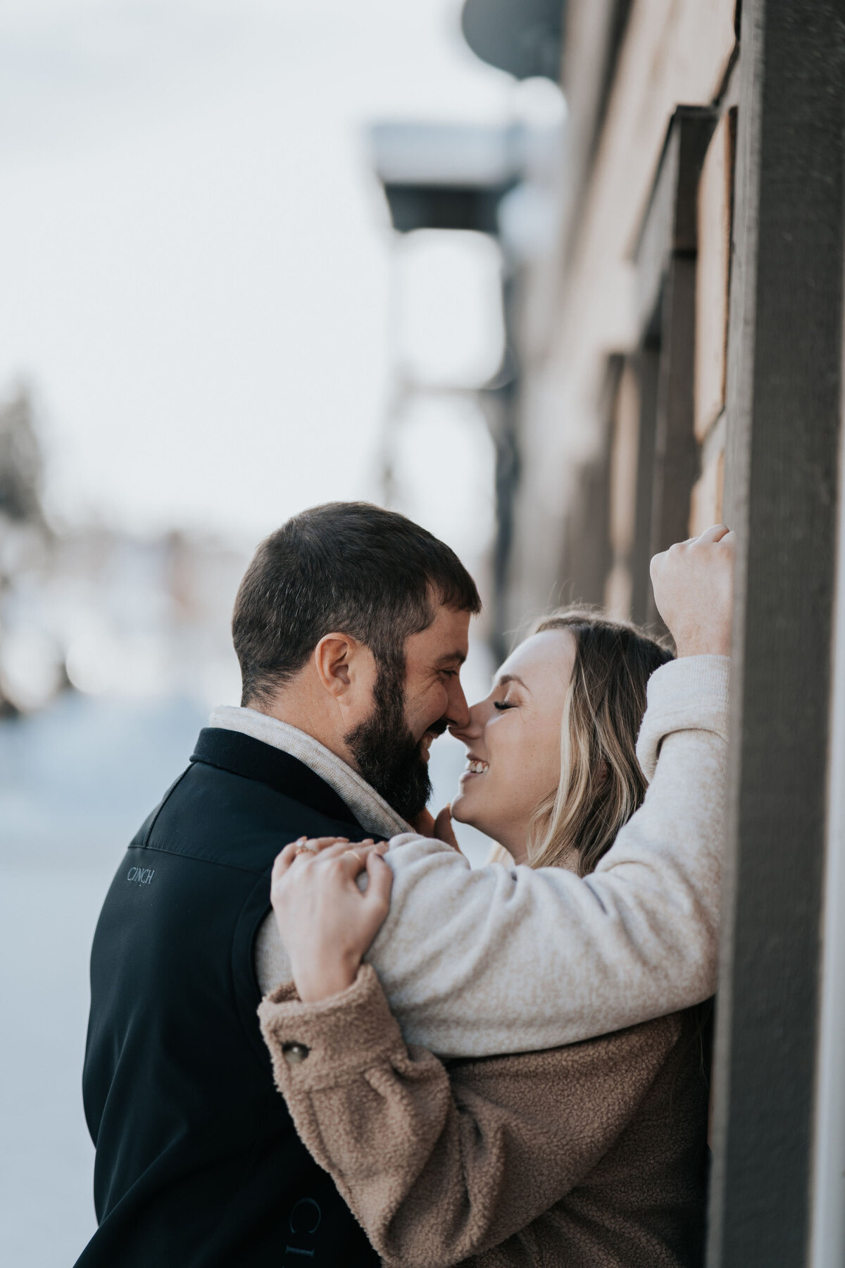 engaged couple kissing while man pushes fiance against wall captured by Idaho Falls Wedding Photographer