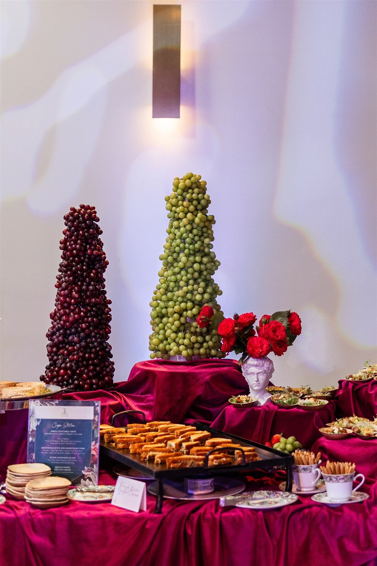 Venue space styled as a bread and butter station, featuring a rustic display of assorted artisan breads, flavored butters, and decorative serving boards arranged on a linen-covered table