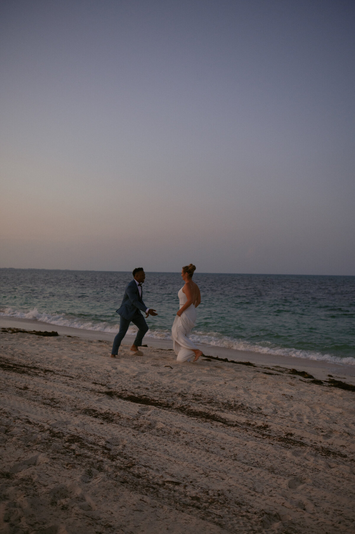 Destination wedding photography couple running on the beach in cancun Mexico for sunset
