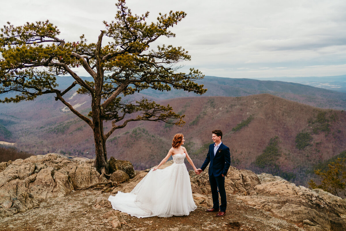 Bride and groom sharing a quiet moment on scenic mountaintop trail