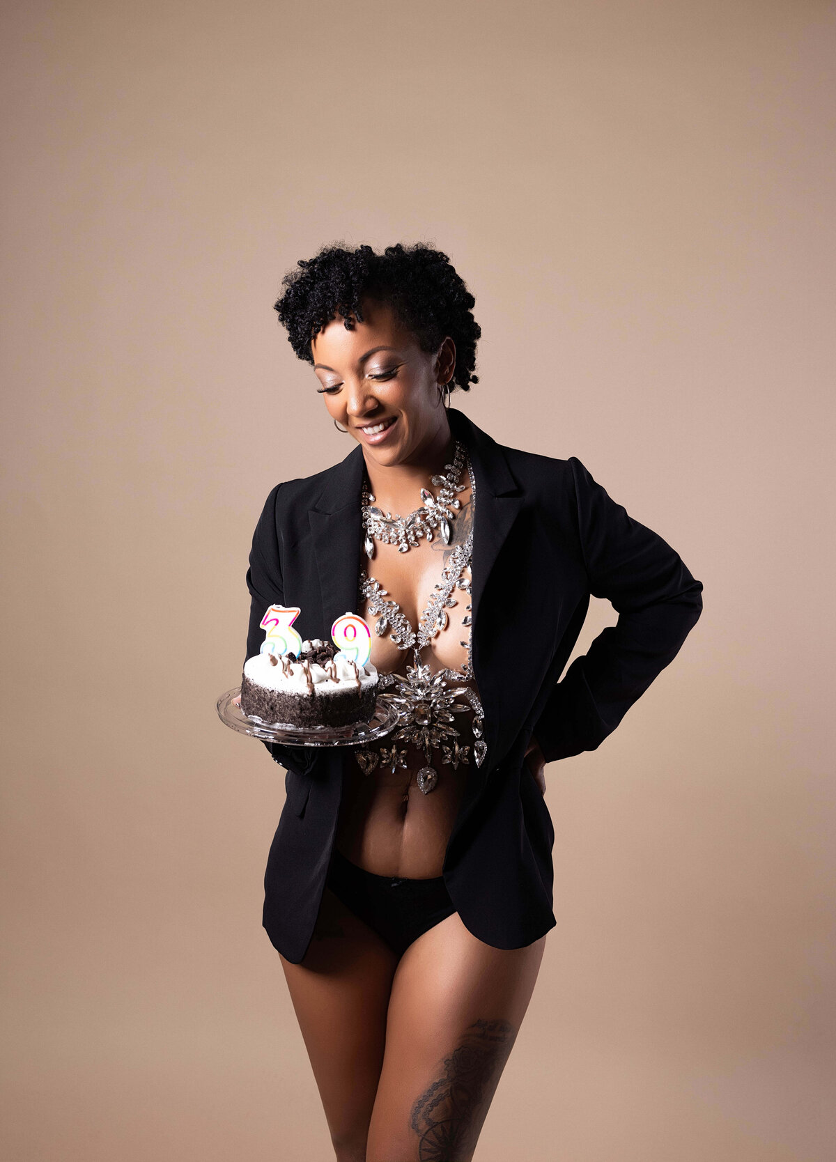 woman standing holding birthday cake in birthday session with reva davis photography