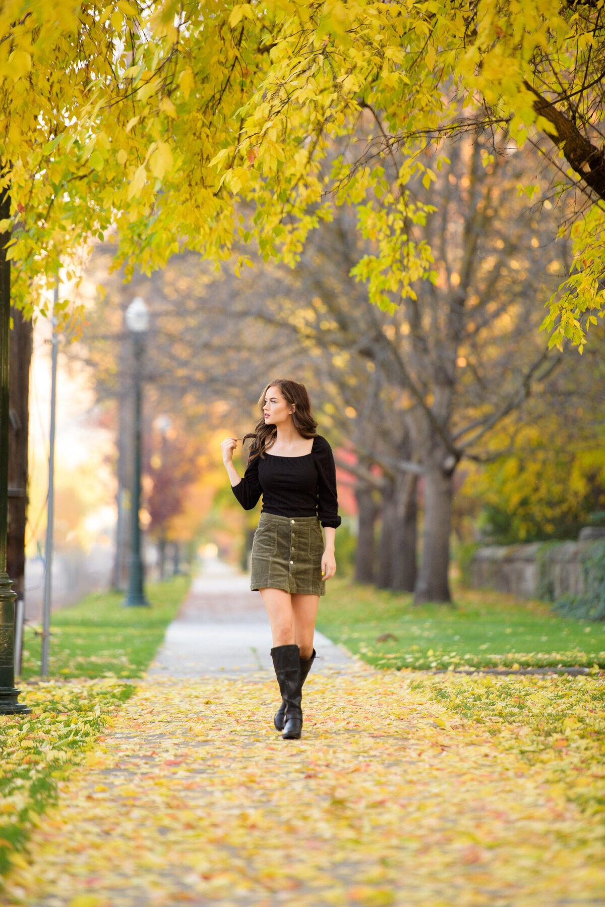 Senior girl walking down a tree lined street in Boise.