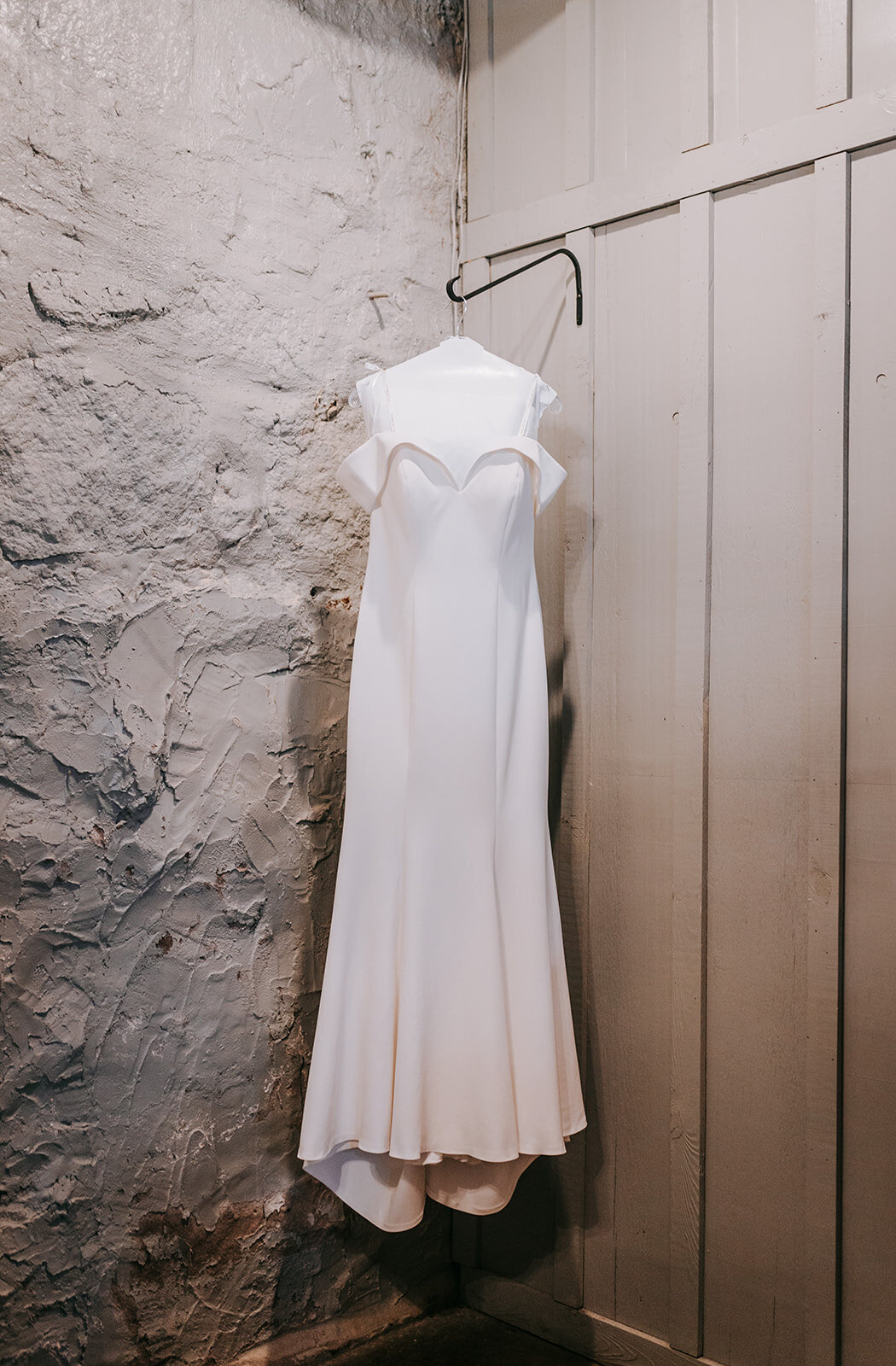 White wedding dress hanging on the wall