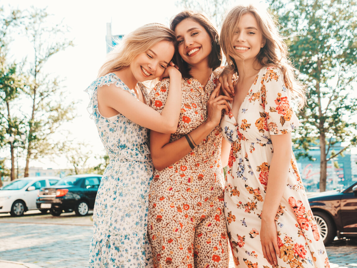 three-beautiful-smiling-girls-trendy-summer-sundress-posing-street