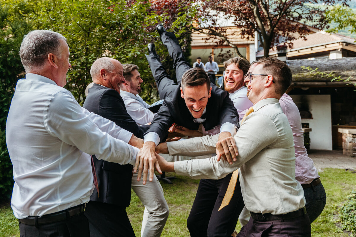Groom jumping with veil thrown in the air