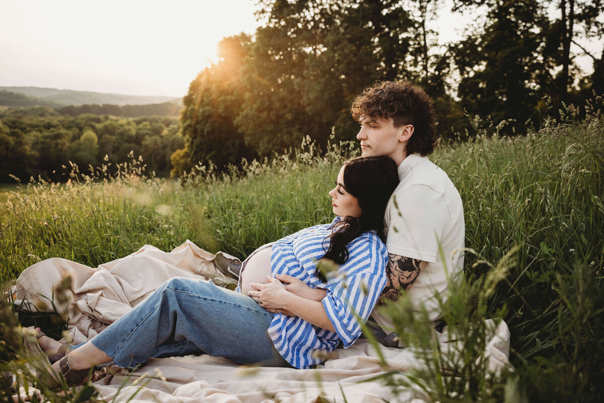 mom and dad sitting on blanket in portrait session with reva davis photography