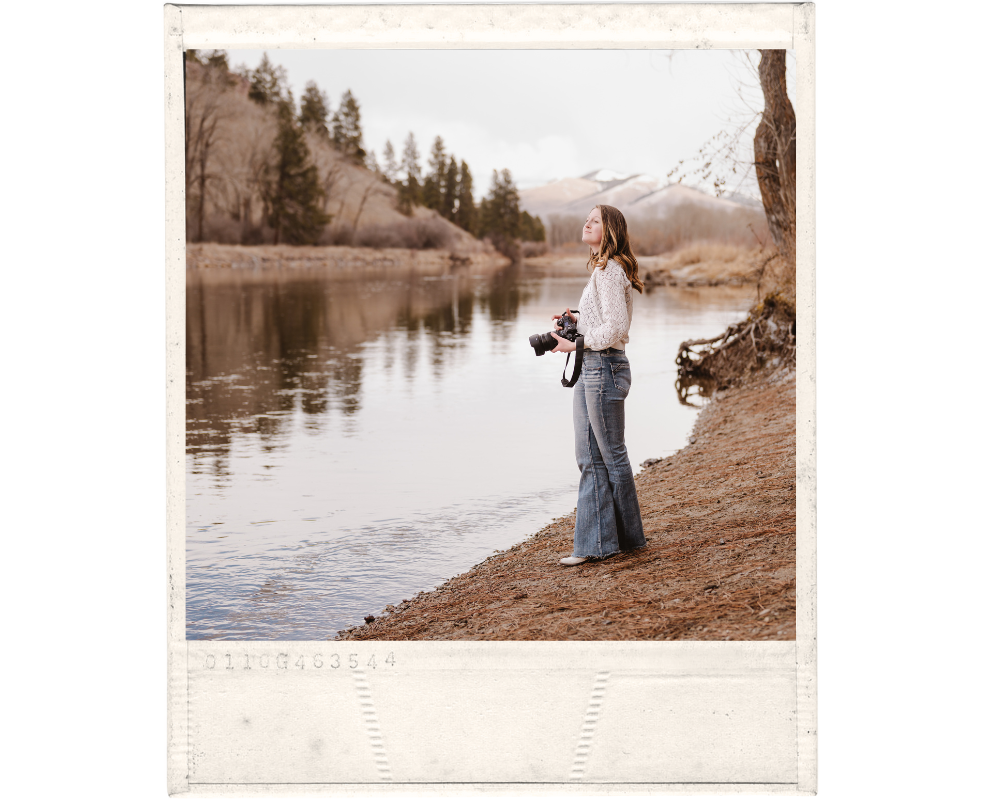 Northern California storytelling photographer stands with camera in front of lake.