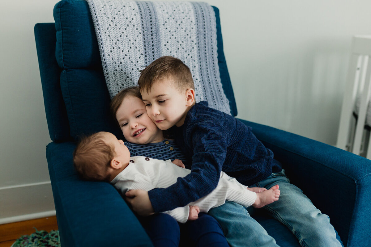Family photoshoot with brother and sister snuggle newborn