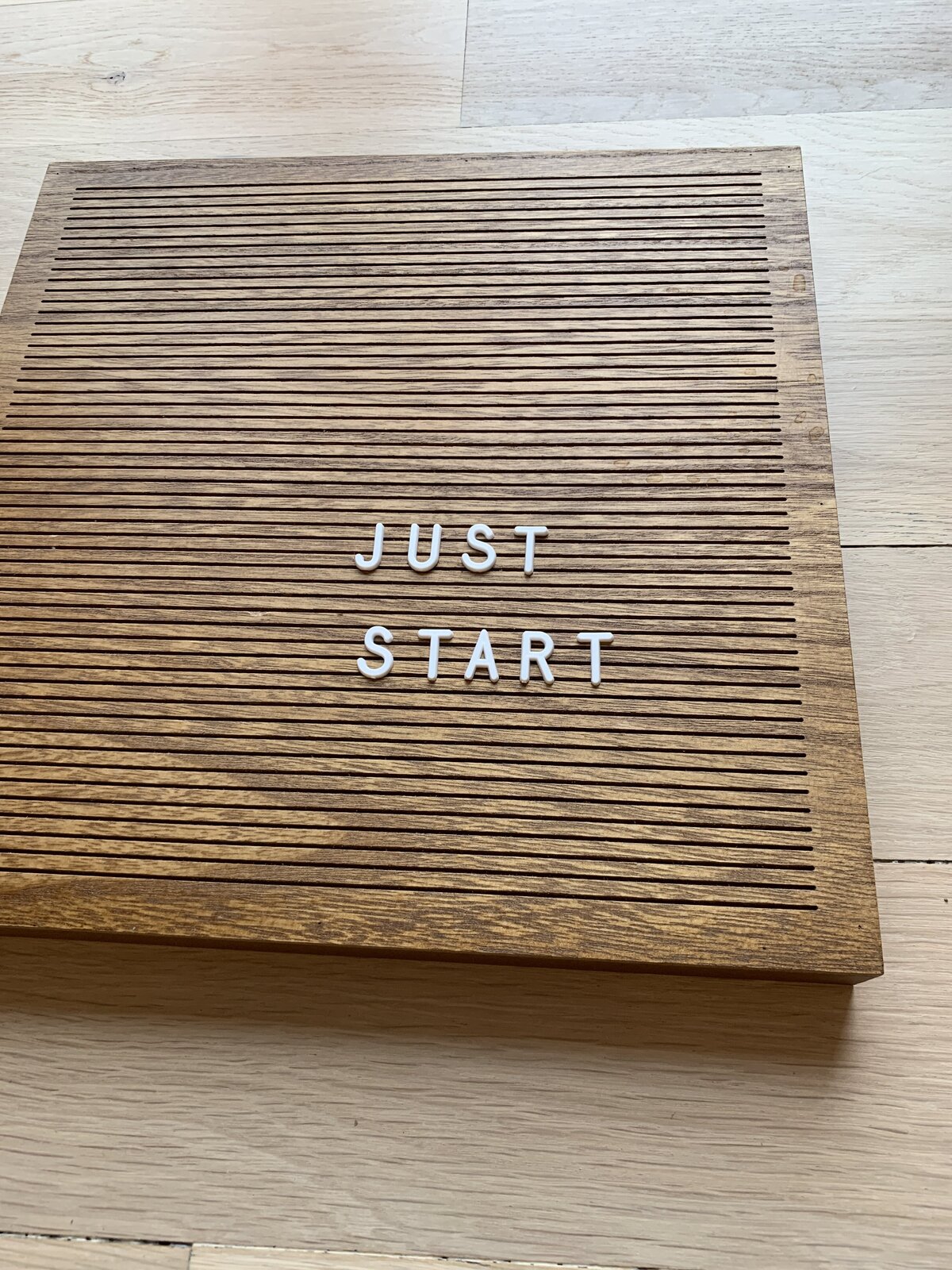 Wood letterboard reading the words just start