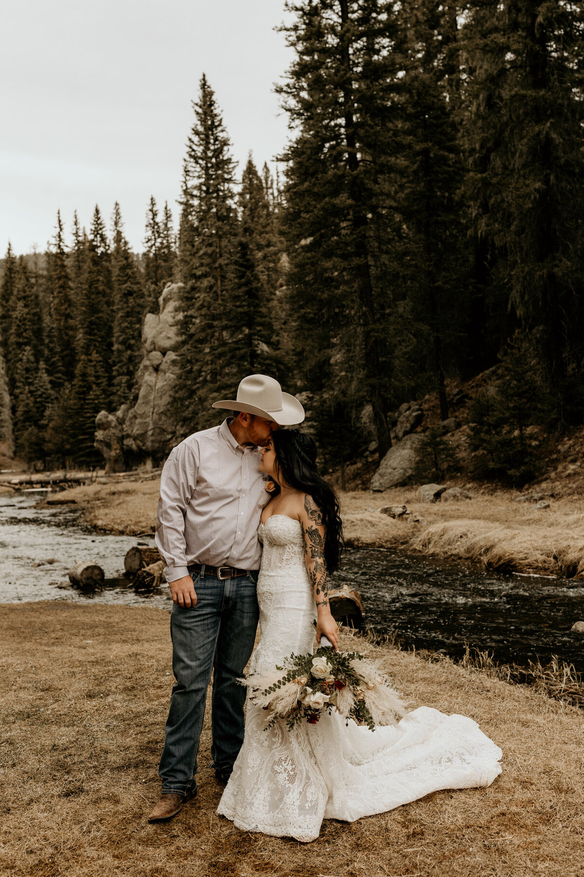 Bride and groom standing in front of a creek in Jemez Springs New Mexico