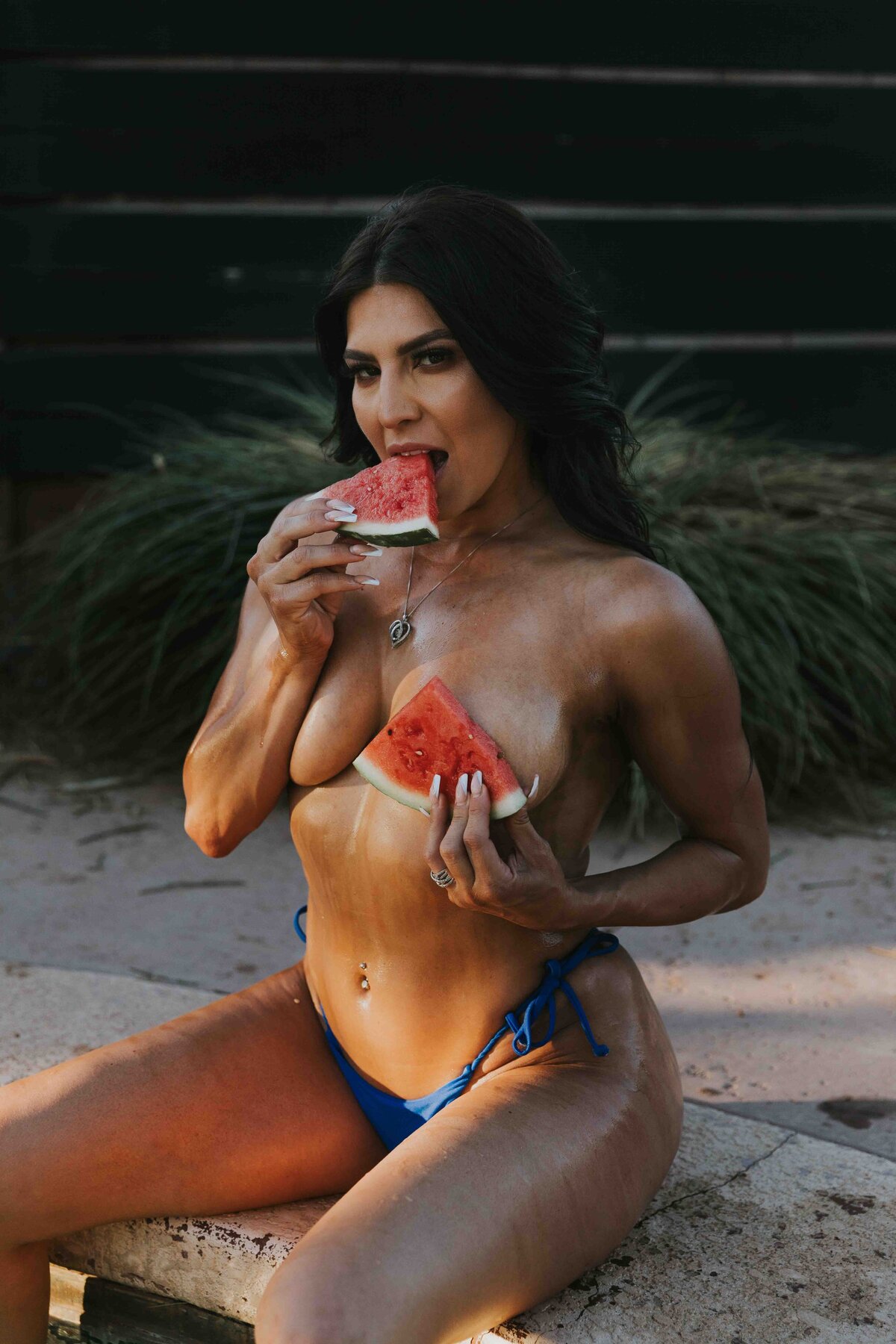 woman using watermelon as a prop during her pool photoshoot