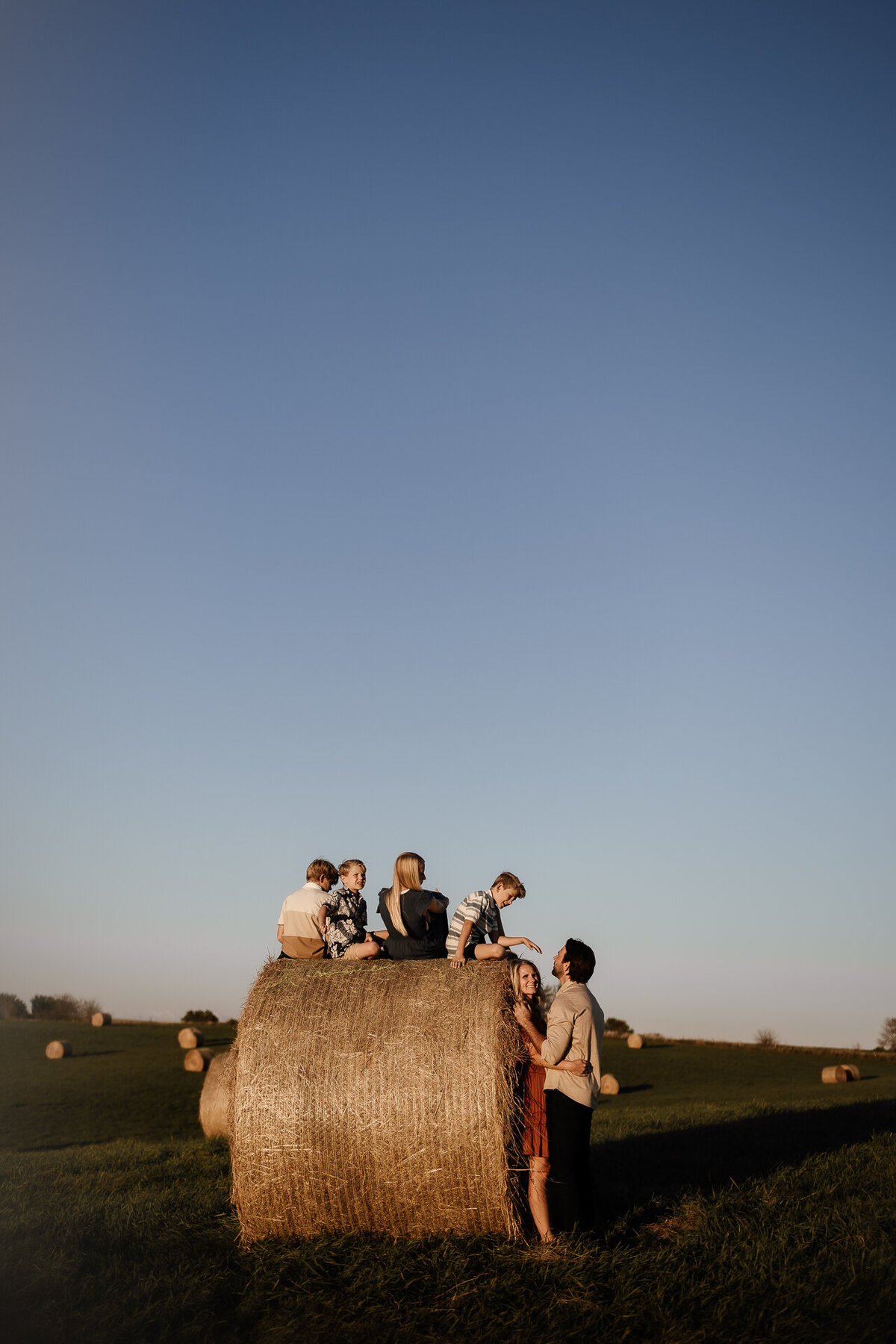 children sitting on hay bale