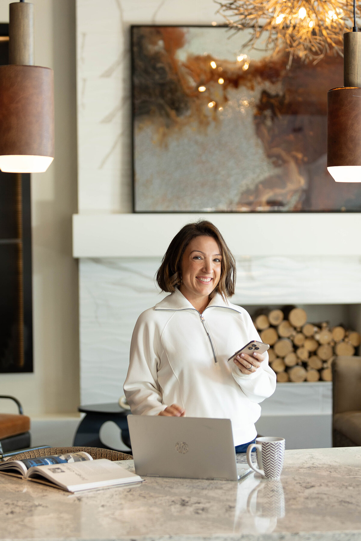 Businesswoman holding a phone with an open laptop